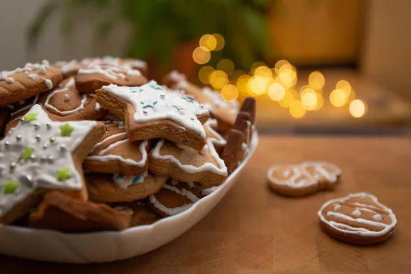 Lebkuchen mit Sahnehäubchen auf rustikalem Tisch mit Lichtern dekorieren. Weihnachtstradition und Advent. Warmer gemütlicher Abend — Stockfoto