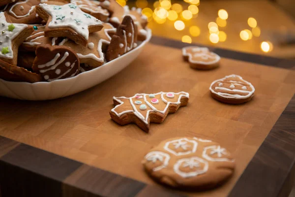 Lebkuchen mit Sahnehäubchen auf rustikalem Tisch mit Lichtern dekorieren. Weihnachtstradition und Advent. Warmer gemütlicher Abend — Stockfoto