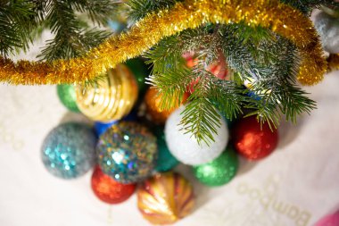 Bulanık Noel topları ağacın altında yerde yatıyor. Odaklı dallar. Tatil konsepti, yeni yıl, Noel.