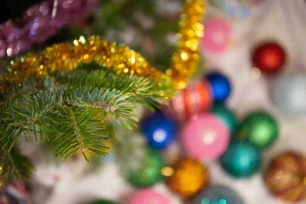 Bolas de Navidad borrosas yacen en el suelo debajo del árbol. Ramas de abeto en foco. concepto de vacaciones, año nuevo, Navidad. — Foto de Stock