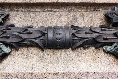 Metal süslemeli beton duvar yüzeyinin yakın çekim resmi.