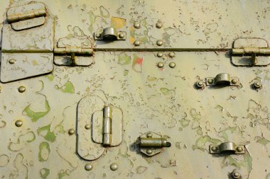 Mekanik parçaları olan eski ve paslı yeşil renkli askeri aracın fotoğrafı..