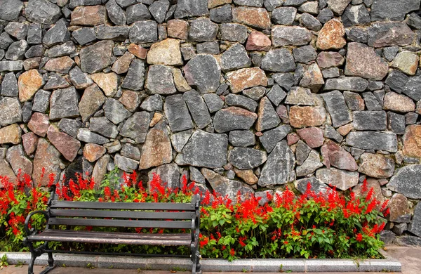 Zdjęcie Zużyte Drewniane Stalowe Ławki Czerwonymi Kwiatami Kamiennym Tle Ściany — Zdjęcie stockowe