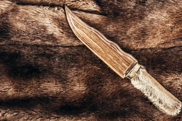 写真は狩猟用ナイフ付きの茶色の動物性毛皮の素材で その上に袖がある — ストック写真