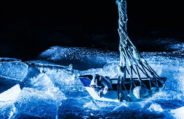 Photo Blue Toned Miniature Sailboat Standing Cracked Ice Surface Dark — Stock Photo, Image