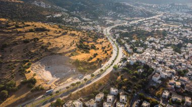 Türkiye 'nin Halicarnas Bodrum kentinde gün batımı, dağların aşağısındaki kentin dolambaçlı yolu boyunca bir manzara. Tarihi yerler