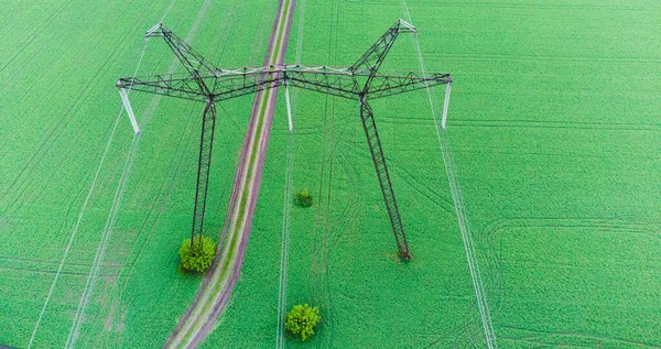 Top Electric high voltage post, High voltage energy transmission. Voltage post.High-voltage tower in green field background. Power distribution.