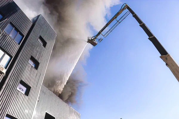 Merdivenlerdeki itfaiyeciler büyük bir yangını söndürüyorlar. İtfaiyeciler ev yangınında. Fotoğraf indir 