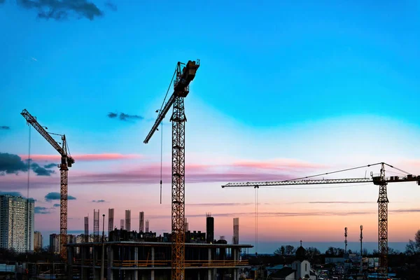 Construction site with crane. Silhouette cranes, industry concept over natural background sunset pastel. Production facility. The crane. Against the sunset — Stock Photo, Image