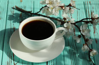 Kayısı çiçeği dallı bir fincan kahve ve kopyalama alanı.