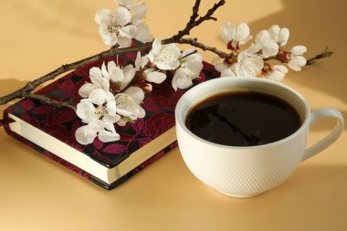 Kayısı çiçeği dallı bir fincan kahve ve kopyalama alanı.
