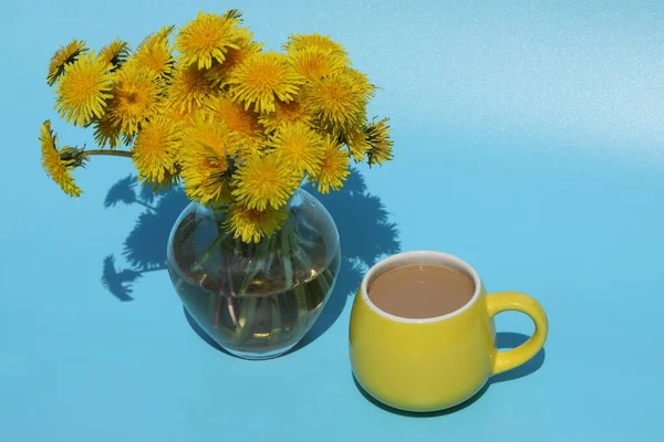 Mavi Arka Planda Bir Fincan Kahveyle Birlikte Parlak Sarı Karahindibalar — Stok fotoğraf