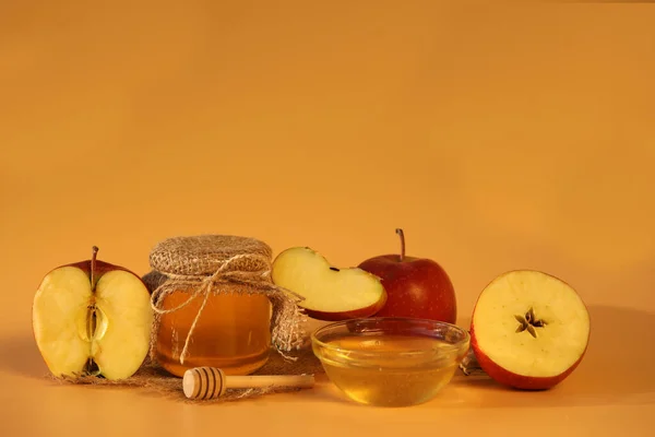 Red fresh apples with honey on yellow background with copy space. Apple feast