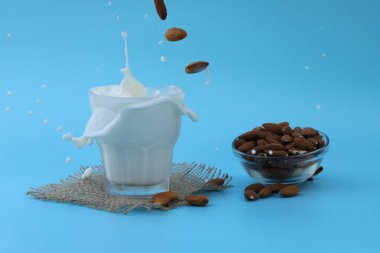 glass of almond milk on the blue background with copy space