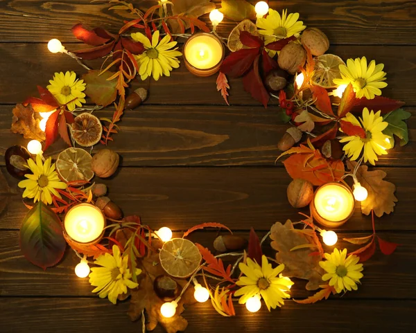 Mumlar, sonbahar yaprakları ve kopyalama alanı olan koyu kırsal ahşap arkaplan