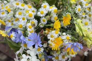 Tahta arka planda fotokopi alanı olan bir buket yaz çiçeği.
