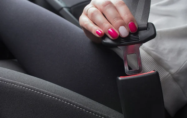 Kobieta zapięcie pasów bezpieczeństwa w samochodzie — Zdjęcie stockowe