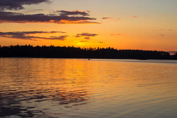 Одинокая лодка на озере во время заката — стоковое фото