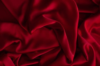 Kırmızı pürüzsüz kumaş dokuyu katlar. Lüks saten kumaş..