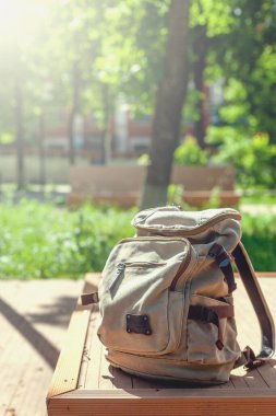Vintage backpack on sunny city street. Hipster traveler bag