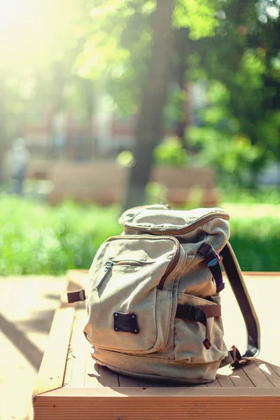 Vintage backpack on sunny city street. Hipster traveler bag