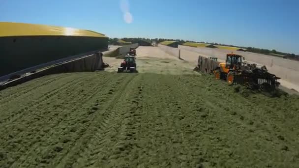 Copter volando alrededor de tractores en un silo en una granja — Vídeo de stock