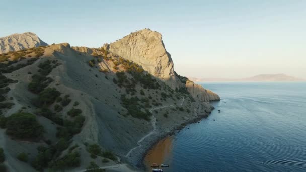 Vliegen over de zee naar de berg bij zonsondergang — Stockvideo
