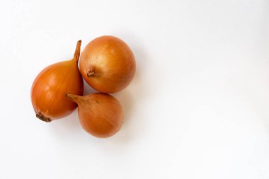 Beyaz arkaplanda üç taze soğan, soyulmamış soğan ve metin için boş alan, üst görünüm