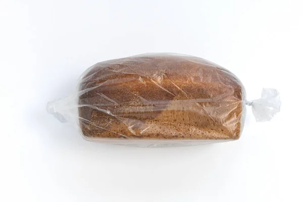 面包在塑料袋中 整个面包在透明的包装中隔离在白色背景 顶部视图 — 图库照片