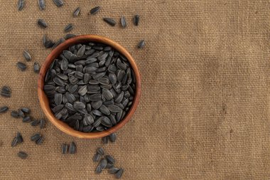 Ahşap kasede siyah ayçiçeği tohumları. Arka planda izole edilmiş. Metin için fotokopi alanı var.