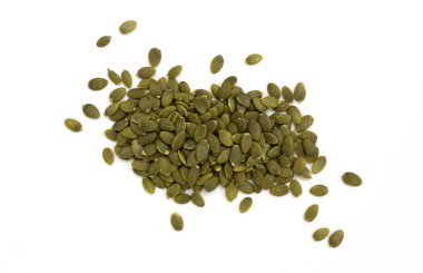 Beyaz arka planda izole edilmiş bir yığın yeşil kabak çekirdeği, soyulmuş tohumlar, üst manzara.