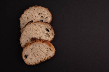 Siyah zemin üzerinde izole edilmiş yazı için üç dilim buğday ekmeği ve boş alan, soğanlı taze buğday ekmeği, üst görünüm