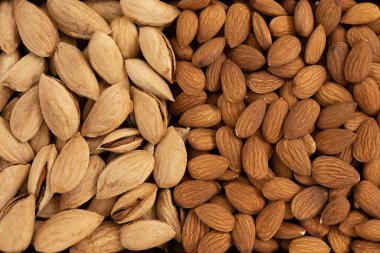 Kabuğu soyulmuş ve soyulmamış badem yığını yakın plan ve doku, vejetaryenler için sebze proteini, düz yatak.