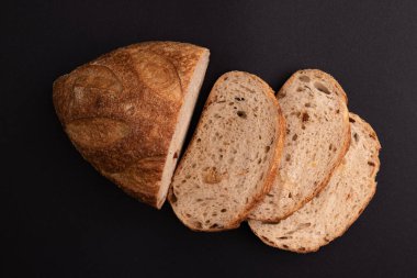 Siyah zemin üzerinde altın çıtır çıtır ekmek, domatesli organik somun, İtalyan yemeği.