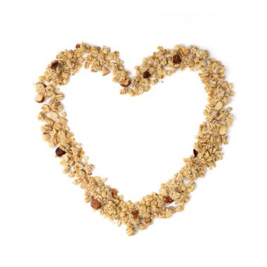 Beyaz arka planda fındıklı granola musli 'nin kalp şekli, konsept sağlıklı yemek, üst görünüm