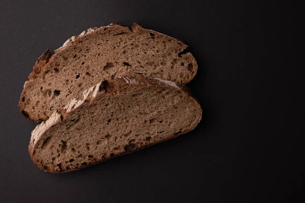 İki dilim çavdar ekmeği, siyah arka planda izole, üst manzara, taze lezzetli ev yapımı sağlıklı pişirme.