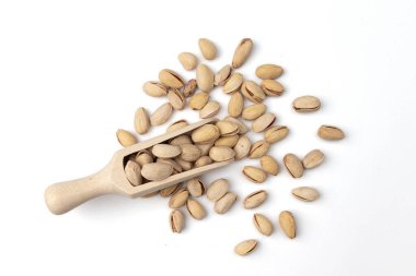 Beyaz arka planda izole edilmiş ahşap kepçe şam fıstığı, sağlıklı atıştırmalık, vejetaryen yemeği.