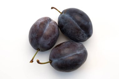 three ripe plums isolated on white background, fresh fruits close-up