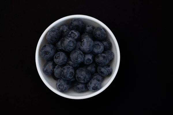 陶瓷碗中新鲜蓝莓 黑色背景隔离 顶部视图 — 图库照片