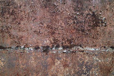 Çizikler ve çatlaklarla eski paslı metal dokusu. Eskimiş koyu renkte bir metal arkaplan.