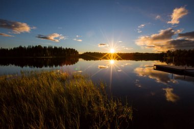 İsveç 'in kuzeyinde Laponya' da bir gölde sonbahar günbatımı.