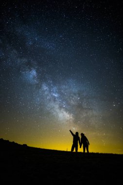 Milky way and couple in Serra Del Montsec, Lleida, Spain. clipart