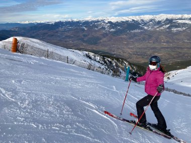 MASELLA, İspanya - 14 Aralık 2020; La Masella, Pyrenees, İspanya 'da koruma maskeleriyle kayak yapan kız