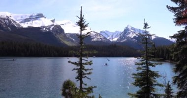 Yaz manzarası ve Maligne Gölü 'nde kayak yapan ve balık tutan insanlar, Jasper Ulusal Parkı, Kanada