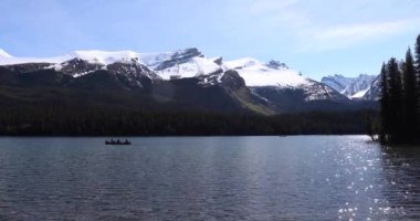 Yaz manzarası ve Maligne Gölü 'nde kayak yapan ve balık tutan insanlar, Jasper Ulusal Parkı, Kanada