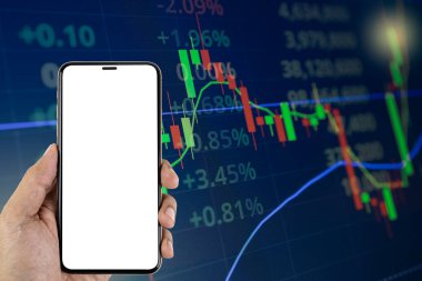 Man hand holding smartphone white blank screen on Stock market or forex trading chart and candlestick chart suitable for financial investment.