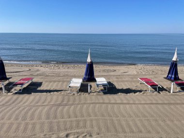 Sabahleyin ıssız sahilde şemsiyeler. Yüksek kalite fotoğraf