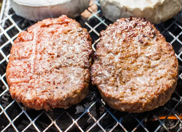 Hamburguesas a la parrilla con llamas bailando cocinadas a la perfección —  Fotos de Stock