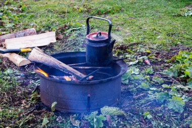 Eski çaydanlık kamp ateşinde kaynıyor. Klasik küçük çaydanlık. Sabahları dışarıda sıcak bir şeyler içerim. Dağlarda seyahat et..