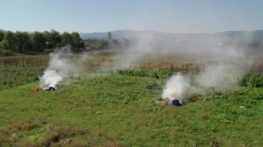 Hava görüntüsü. Sahada kuru çim yanıkları var. Çayır Tarlasında Çalı Ateşi ve Duman. Dünya Ekolojik Sorunları Hava Kirliliği. 